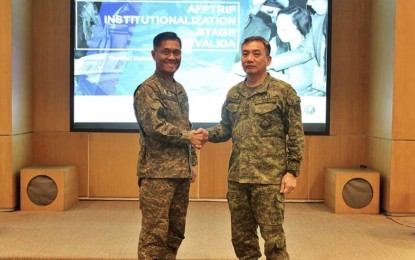 <p><strong>AFP TRANSFORMATION ROADMAP.</strong> Lt. Gen. Roberto Ancan, chief of the Central Command (right) poses with an official from the Office of the Strategic and Strategy Management of the Armed Forces of the Philippines (AFP) after presenting the "revalida" for the command's application for institutionalized status in the AFP transformation roadmap for institutionalization pathway (AFPTRIP). Col. Allan Napisa, head of General Strategy and Management Office of Centcom, said on Monday (March 2, 2020) that among their gains from the institutionalized status was the enhancement of their information and communications technology system. <em>(File photo courtesy of Senior Master Sergeant Vicente A. Estonilo)</em></p>