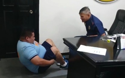 <p><strong>FITNESS PROGRAM</strong>. Col. Romeo Baleros (seated), director of Negros Occidental Police Provincial Office, encourages overweight police officer, alias “Big Boy”, while doing sit-ups at his office inside the Camp Alfredo Montelibano Sr. in Bacolod City. Baleros is organizing a fitness camp to also help other obese policemen lose weight. <em>(Screen grab from Col. Romeo A. Baleros' Facebook account)</em></p>