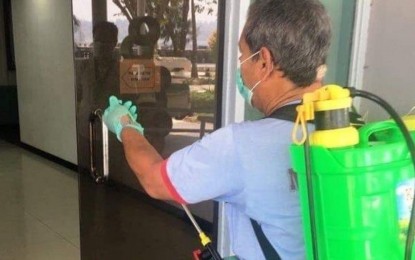 <p><strong>DISINFECTION</strong>. A sanitary technician sprays liquid disinfectant at the entrance of an office in the Subic Bay Metropolitan Authority (SBMA) on Sunday (March 8, 2020). This was done following the declaration by President Rodrigo Duterte of a state of public health emergency due to heightened Covid-19 threat. <em>(Photo by Mahatma Datu)</em></p>