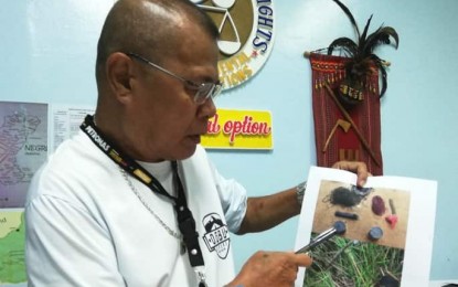 <p><strong>HR VIOLATION</strong>. Dr. Jess Cañete, provincial chief of the Commission on Human Rights in Negros Oriental, points to an image of alleged improvised explosive devices that were recovered following an ambush in Guihulngan City last March 3, 2020. In that attack allegedly perpetrated by the New People's Army, at least four soldiers were wounded but are now in stable condition. <em>(Photo by Judy Flores Partlow)</em></p>