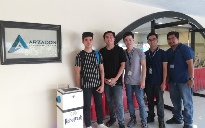 <p><strong>INVENTIONS</strong>. Works of Colegio de Dagupan students (from left to right) Dexter De Guzman, Franz Velasco, Lorden Kim Cornel and their advisers are part of the exhibit at the Arzadon Research Center of their school. Their inventions include a smart trashcan with De Guzman, a smart home by Cornel, and a smart mirror by Velasco. <em>(Photo by Hilda Austria)</em></p>