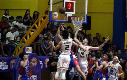 <p><strong>EQUALIZER.</strong> Arnold Gamboa (1) defies two defenders to score an undergoal stab during the San Juan Knights' 74-66 victory over the host Palayan City Capitals at the Gapan City Gymnasium in Nueva Ecija on Sunday night (March 8, 2020). The Knight's win tied their Community Basketball Association (CBA) Executive Cup best-of-three championship series. <em>(PNA photo by Jess Escaros)</em></p>