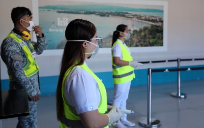 <p><strong>WELL-PROTECTED.</strong> Airport personnel at the Caticlan Airport wear protective gloves and masks as they await passengers coming into the island on March 11, 2020. The government and tourism stakeholders have mounted several recovery flights and transportation for passengers stranded due to the enhanced community quarantine imposed on entire Luzon. <em>(PNA photo by Joey Razon)</em></p>