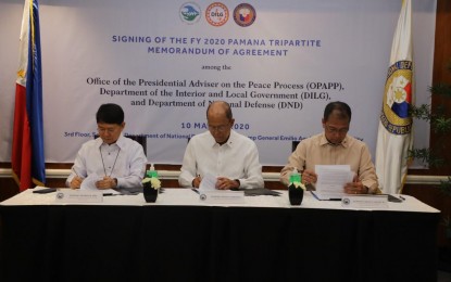 <p><strong>TRIPARTITE AGREEMENT</strong>. Interior and Local Government Secretary Eduardo Año, Defense Secretary Delfin Lorenzana, and Presidential Peace Adviser Carlito G. Galvez Jr. sign a tripartite memorandum of agreement (MOA) at Camp Aguinaldo, Quezon City on March 10, 2020. The MOA will be used for the transparent implementation of 643 projects under the PAMANA Program throughout the country. <em>(Photo courtesy of OPAPP)</em></p>