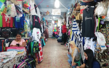 <p><strong>BUSINESS DOWN.</strong> No tourists were seen frequenting these souvenir shops on the front beach of the famous Boracay Island at 10 a.m. on Thursday (March 12, 2020). Risalyn Joy Tillo (front, right) said they barely have customers since the coronavirus disease 2019 (Covid-19) broke out. <em>(PNA Photo by Gail Momblan)</em></p>