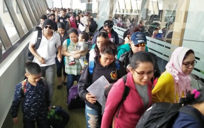 <p>Arriving passengers, mostly OFWs, at the Ninoy Aquino International Airport <em>(PNA file photo by Cristina Arayata)</em></p>