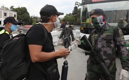<p><strong>CHECKPOINT</strong>. A policeman talks with a commuter from Bulacan who decided to walk due to heavy traffic caused by a checkpoint set up near the boundary of Caloocan and Bulacan on Sunday (March 15, 2020). Malacañang on Monday said President Rodrigo Duterte has placed the entire Luzon under “enhanced community quarantine” to control the coronavirus disease outbreak in the country. <em>(PNA photo by Oliver Marquez)</em></p>