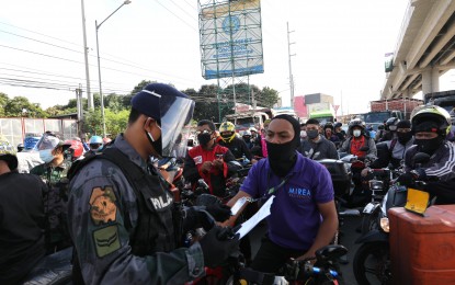 <p><strong>CHECKPOINT.</strong> After presenting documents to authorities, a motorcycle rider was allowed to pass a checkpoint on Marcos Highway at the border of Marikina City and Cainta, Rizal on Tuesday (March 17, 2020). Luzon is currently under an enhanced community quarantine to prevent further spread of the coronavirus disease 2019. <em>(PNA photo by Joey O. Razon)</em></p>