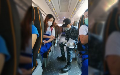 <p><strong>FREE RIDES FOR HEALTH WORKERS</strong>. A Philippine Coast Guard (PCG) member checks the ID of a passenger aboard one of its buses providing free bus rides to health workers in Metro Manila on Wednesday (March 18). The Department of Transportation (DOTr) on Tuesday increased the number of routes providing free rides to nine, with a total of 61 buses. <em>(Photo courtesy of PCG)</em></p>