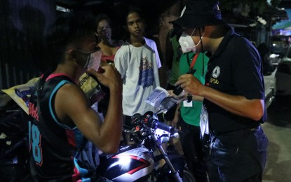 <p><strong>CURFEW VIOLATORS</strong>. A barangay police officer apprehends violators of the enhanced community quarantine’s curfew hours in Barangay Pasong Putik, Novaliches, Quezon City on March 17, 2020. The Philippine National Police on Sunday (March 29, 2020) said curfew violators will still face arrest and possibly prosecution. <em>(PNA photo by Oliver Marquez)</em></p>