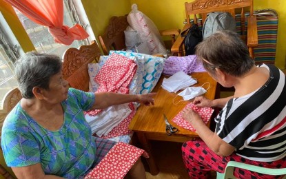 <p>'<strong>BAYANIHAN' AMID COVID-19.</strong> Two elderly residents of Barangay Cabugao in Bato, Catanduanes, "Nanay Alice" and "Nanay Ines", are among the volunteers in making washable face masks to be distributed to villagers for free. The initiative was the brainchild of Marie Grace Molina, one of the good Samaritans of the town<em>. (Photo courtesy of Marie Grace Molina)</em></p>