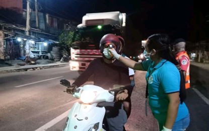 <p><strong>CHECK UPON ENTRY.</strong> A health worker checks the body temperature of a motorist entering Tacloban City. The city government, starting on Wednesday (March 18, 2020), imposed penalties on establishments and persons who are non-compliant with measures to prevent the spread of the coronavirus disease 2019 (Covid-19). <em>(Photo courtesy of Tacloban city government)</em></p>