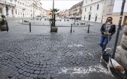 <p>A woman wearing a protective mask walks with her dog in Piazza Navona, downtown Rome, Italy, on March 17, 2020. <em>(Riccardo De Luca - Anadolu Agency)</em></p>