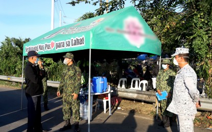 <p><strong>CHECKPOINT.</strong> Defense Secretary Delfin Lorenzana (in black jacket) visits one of the checkpoints at the border of Metro Manila and Cavite on Wednesday (March 18, 2020). Lorenzana ordered troops to comply with President Rodrigo Duterte's unilateral ceasefire. <em>(Photo courtesy of DND Public Affairs Office)</em></p>