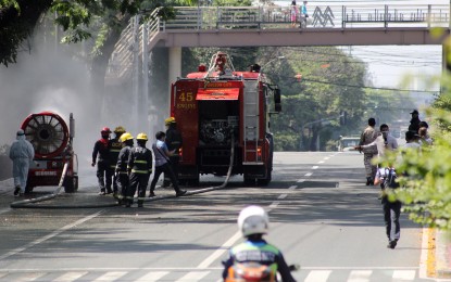 <p><strong>DISINFECTION</strong>. Bureau of Fire Protection and Quezon City Disaster Risk Reduction and Management Council personnel conduct disinfection along East Avenue in Quezon City on Thursday (March 19, 2020). The city government has intensified sanitation measures in line with the Luzon-wide enhanced community quarantine to curb the spread of coronavirus disease.<em> (PNA photo by Joey O. Razon)</em></p>
