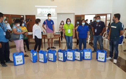 <p><br /><strong>ALCOHOL RATION.</strong> MMSU President Shirley C. Agrupis (3rd from left) and Ilocos Norte Governor Matthew Marcos Manotoc (4th from left) lead the distribution of 20 liters of 70-percent ethyl alcohol from nipa sap to local government units and churches in the province on Friday (March 20, 2020). The Nipahol was produced by the National Bio-Energy Research and Innovation Center of the Mariano Marcos State University. <em>(PNA photo by Reynaldo E. Andres)</em></p>