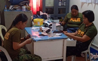 <p><strong>INNOVATIVE.</strong> Police officers in Iligan City make face masks out of their old police uniforms to compensate for the shortage of face masks among their personnel, especially those who are assigned at the checkpoints. Some local police units also resort to making their own face shields to augment their supplies.<em> (Photo courtesy of Iligan City Police Mobile Force)</em></p>