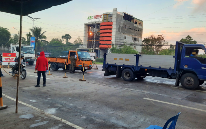 <p><strong>STRICT MEASURE</strong>. A health worker (in red jacket) checks on motorists using a thermal scanner while a soldier (far right) mans the checkpoint by inspecting a cargo truck as the city implements the enhanced community quarantine against the coronavirus disease 2019 (Covid-19) starting Monday (March 23, 2020). The provincial epidemiology and surveillance unit said Kidapawan and the rest of North Cotabato province remain Covid-19 free. <em>(Photo courtesy of North Cotabato PIO)</em></p>