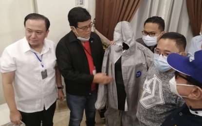 <p><strong>PERSONAL PROTECTIVE EQUIPMENT.</strong> Mayor Edgardo Labella inspects one of the 2,000 personal protective equipment (PPE) before these are distributed to the frontliners in the fight against Covid-19 at the Cebu City Hall on Monday (March 23, 2020). Labella said the PPE from the city government will protect the frontliners from the viral disease. <em>(PNA photo by Ramil Ayuman)</em></p>