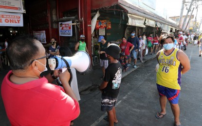<p><strong>REOPENING ECONOMY.</strong> Marketgoers practice physical distancing with the help of a barangay personnel in this undated photo as the government tries to reopen the economy. Malacañang on Thursday (Dec. 17, 2020) said fewer Filipinos are experiencing involuntary hunger due to efforts to reopen the economy amid the coronavirus disease 2019 pandemic. <em>(File photo)</em></p>