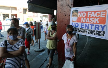 <p><strong>ACT AS ONE VS. COVID-19</strong>. People wear face masks while on queue to enter the Angono Public Market in Angono, Rizal on Tuesday (March 24, 2020). Malacañang on Wednesday urged Filipinos to “act as one” to prevent further transmission of the coronavirus disease.<em> (PNA photo by Joey O. Razon)</em></p>