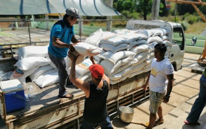 <p><strong>RELIEF AID</strong>. Residents unload sacks of rice to be distributed to the different barangays in Solsona, Ilocos Norte on Tuesday (March 24, 2020). The relief items came from the provincial government to be given to daily wage earners affected by the Luzon-wide enhanced community quarantine.<em> (Contributed photo by Rap-rap Parado)</em></p>