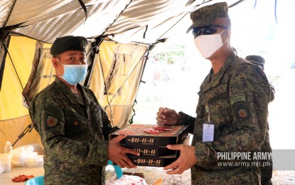<p><strong>FREE PIZZA.</strong> A soldier receives three boxes of pizza at a checkpoint in Valenzuela City on Tuesday (March 24, 2020). Aside from free pizzas, the Philippine Army headquarters also sent a medical team to boost the morale of soldiers manning the checkpoints in Luzon. <em>(Photo courtesy of Army Chief Public Affairs Office)</em></p>