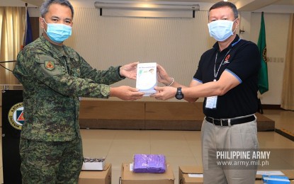 <p><strong>DONATION.</strong> Army vice commander, Maj. Gen. Reynaldo Aquino (left) receives a thermal scanner from PNOC-EC president and retired Air Force commander, Lt. Gen. Rozzano Briguez (right) in a ceremony in Fort Bonifacio, Taguig City on Thursday (March 26, 2020). Aside from the thermal scanners, the state oil exploration firm also donated eye protectors, face masks and gloves to Army troops who are among the front-liners in the battle against the coronavirus disease 2019. <em>(Photo courtesy of Army Chief Public Affairs Office)</em></p>