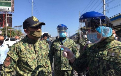 <p><strong>ENSURING COPS' SAFETY.</strong> PNP deputy chief for operations, Lt. Gen. Guillermo Eleazar (right) visits a checkpoint at the border of Metro Manila and Cavite on Thursday (March 26, 2020). Eleazar has been visiting quarantine control points in Luzon to check on the condition of police officers who are enforcing the Luzon-wide enhanced community quarantine.<em> (Contributed photo)</em></p>