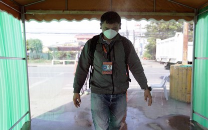 <p><strong>DECONTAMINATION TENT.</strong> An employee of the Department of Public Works and Highways in Caraga Region passes through a decontamination tent at the entrance of the agency's regional office in Butuan City on Thursday (March 26). The decontamination tent is among the measures the agency is implementing to contain the spread of coronavirus disease. <em>(Photo courtesy of DPWH-13 Information Office)</em></p>