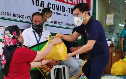 <p><strong>COVID-19 ASSISTANCE. </strong>Lawyer Naguib Sinarimbo (right), Minister of the Interior and Local Government in the Bangsamoro Autonomous Region in Muslim Mindanao, hands over a pack of relief goods to a Cotabato City beneficiary on Thursday (March 26, 2020) to help cushion the effect of the health crisis brought by the coronavirus disease 2019 due to the implementation of community quarantine across the region. He announced the availability of some PHP155 million for local government units to address the threat brought by the dreaded disease. <em>(Photo courtesy of BPI-BARMM)</em></p>
