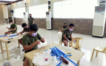 <p><strong>FACE SHIELDS.</strong> Troops from the Naval Sea Systems Command in Cavite City make face shields for their colleagues deployed at quarantine checkpoints on Wednesday (March 25, 2020). These face shields, made of transparent film, foam, garter and double-sided tape, were made to address the shortage of personal protective equipment (PPE) supply for front-liners amid the public health emergency. <em>(Photo courtesy of Naval Public Affairs Office)</em></p>