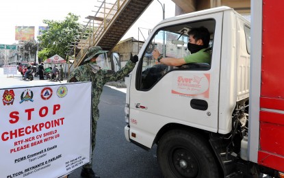 <p>A cargo truck passing through a checkpoint in Quezon City. <em>(File photo)</em></p>