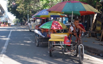<p><strong>CORONAVIRUS BRUNT</strong>. Pedicab drivers anxiously wait for scarce passengers amid the coronavirus disease scare along North Avenue in Quezon City on Thursday (March 12, 2020). Pedicab drivers are among the 18-million low-income households who will benefit from the PHP200 billion two-time emergency subsidy amid the Covid-19 crisis. <em>(PNA photo by Robert Oswald P. Alfiler)</em></p>