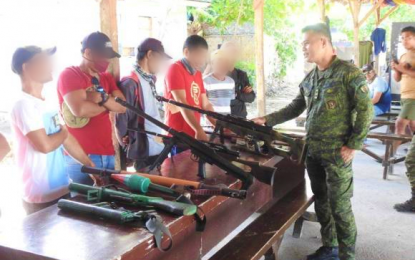 <p><strong>SURRENDER.</strong> Lt. Colonel Elmer Boongaling (right), Army’s 33rd Infantry Battalion commander, views the surrendered firearms and talks with several of the 29 surrenderers from the Daesh-inspired Bangsamoro Islamic Freedom Fighters in Rajah Buayan, Maguindanao on Tuesday (March 31, 2020). The former radicals opted to surrender to the government to live normal lives once more with their families. <em>(Photo courtesy of 33IB)</em></p>
