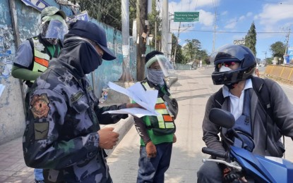 <p><strong>ZERO INCREASE IN COVID-19 CASES</strong>. A personnel of the Philippine National Police (PNP) checks the quarantine pass of a motorcycle rider at a checkpoint near the boundary of Cebu and Talisay cities on Wednesday (April 1, 2020). The city government of Cebu is enforcing stricter border control in spite of the reported zero increase in Covid-19 cases for two straight two days in Central Visayas. <em>(PNA photo by John Rey Saavedra)</em></p>