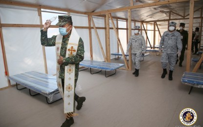 <p><strong>QUARANTINE FACILITY.</strong> Navy officials lead the blessing of the emergency quarantine facility turned over by the WTA Architecture and Design at the Naval Combat Engineering Brigade in Taguig City on Wednesday (April 1, 2020). The facility will house persons under monitoring (PUMs) and patients under investigation (PUIs) for the coronavirus disease 2019. <em>(Photo courtesy of Naval Public Affairs Office)</em></p>