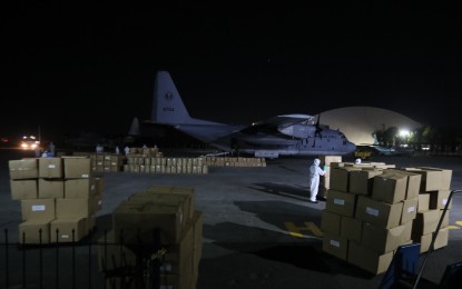 <p><strong>ARRIVAL OF PPE SETS</strong>. Philippine Air Force (PAF) personnel in hazmat suits unload tons of government-procured personal protective equipment (PPE) from a PAF C-130 cargo plane at the Villamor Airbase in Pasay City on Tuesday evening (March 31, 2020). The PPE sets are intended for front-liners in the fight against Covid-19. <em>(PNA photo by Avito C. Dalan)</em></p>