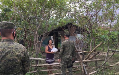 <p><strong>ADOPT-A-BARANGAY.</strong> Lt. Col. Reandrew Rubio, acting commander of the Army's 91st Infantry Battalion, leads the distribution of food packs to indigent residents in Barangay Calabuanan, Baler, Aurora on Saturday (April 4, 2020). The initiative is part of their enhanced Adopt-a-Barangay program. <em>(Photo by Jason de Asis)</em></p>