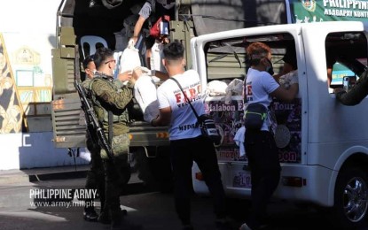 <p><strong>FOOD AID</strong>. Philippine Army (PA) personnel help distribute some 6,000 family food packs (FFPs) donated by the Asian Development Bank (ADB) to residents of Barangay Hulong Duhat, Malabon City on Saturday (April 4, 2020). Army spokesperson Col. Ramon Zagala said the 6,000 families in the barangay were the initial beneficiaries of some PHP250 million worth of donations coming from the ADB. (<em>Photo courtesy of the Philippine Army</em>) </p>