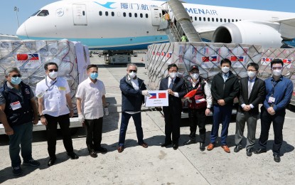 <p><strong>'WE FIGHT AS ONE.'</strong> Chinese Ambassador Huang Xilian (5th from right) turns over medical supplies to Foreign Affairs Secretary Teodoro L. Locsin Jr. (4th from left) at the Ninoy Aquino International Airport (NAIA) in Parañaque City on Sunday (April 5, 2020). The Chinese government has donated 300,000 surgical masks, 30,000 medical N95 masks, 5,000 medical protective suits, 5,000 medical face shields, and 30 non-invasive ventilators. <em>(PNA photo by Joey Razon)</em></p>