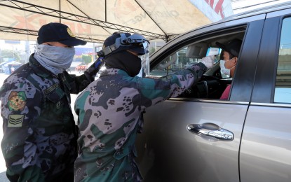 <p>Police officers at a quarantine checkpoint. <em>(PNA photo by Joey Razon)</em></p>