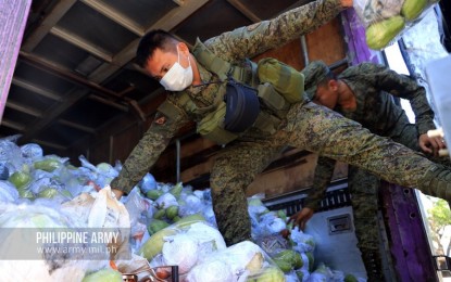 <p><strong>HELPING HAND.</strong> Army troops haul packs of mixed vegetables and rice for residents of two villages in Makati and Pasay City on Monday (April 6, 2020). The food packs were given as relief aid to families whose livelihood were affected by the enhanced community quarantine in Luzon. <em>(Photo courtesy of Army Chief Public Affairs Office)</em></p>