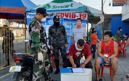 <p><strong>CHECKPOINT ARREST.</strong> Bacolod City resident Jeffrey Rodrigo (seated, right) is arrested at a police checkpoint in Barangay Sum-ag on Monday (April 6, 2020) after he was found in possession of 5 grams of suspected shabu. Rodrigo also failed to present a home quarantine pass as a travel requirement. <em>(Photo courtesy of Bacolod City Police Office)</em></p>
