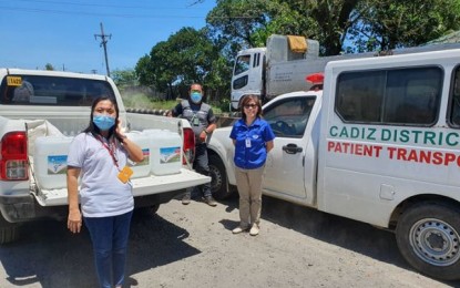 <p><strong>ALCOHOL SUPPLY</strong>. Lawyer Eva Rodriguez (center), administrative head of Victorias Milling Company (VMC), recently turned over ethyl alcohol supply to personnel of Cadiz District Hospital, the designated coronavirus disease 2019 patient care center in Negros Occidental in this undated photo. VMC aims to double its alcohol production capacity this month to address the scarcity of the disinfectant amid the Covid-19 crisis. <em>(Photo courtesy of Victorias Milling Company)</em></p>