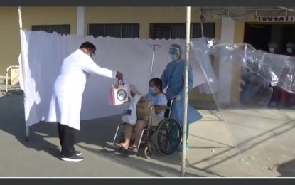 <p><strong>RECOVERED PATIENT</strong>. A doctor, along with other health workers at the Pangasinan Provincial Hospital, greets and applauds one of the two coronavirus disease 2019 patients in the province who recovered on April 7, 2020. The patient was sent home following negative results in the recent repeat test. <em>(Photo courtesy of Province of Pangasinan's Facebook page)</em></p>
<p> </p>