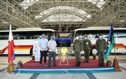 <p><strong>BUS DONATION.</strong> Military officials receive two refurbished buses from representatives of the transport firm Victory Liner in a ceremony in Camp Aguinaldo on Tuesday (April 7, 2020). The buses will be used as shuttles for medical and support personnel going to and from patient care centers in Metro Manila. <em>(Photo courtesy of AFP Public Affairs Office)</em></p>
