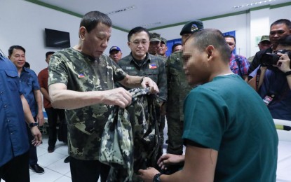 <p><strong>SOCIAL BENEFITS</strong>. President Rodrigo Roa Duterte gives his jacket to one of the wounded soldiers he visited at Camp Teodulfo Bautista Station Hospital in Jolo, Sulu on December 14, 2019. Duterte on Wednesday (April 8, 2020) signed an executive order institutionalizing a comprehensive social benefit program for police and military. <em>(Presidential photo by Robinson Niñal Jr.)</em></p>