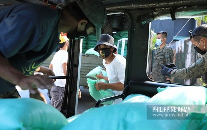 <p><strong>RELIEF DRIVE.</strong> Army troops and barangay officials facilitate the delivery of food packs for indigent families in Barangay Dampalit, Malabon City on Wednesday (April 8, 2020). The relief packs are part of the PHP250 million donation given by the Asian Development Bank for indigent families amid the enhanced community quarantine in Luzon. <em>(Photo courtesy of Army Chief Public Affairs Office)</em></p>