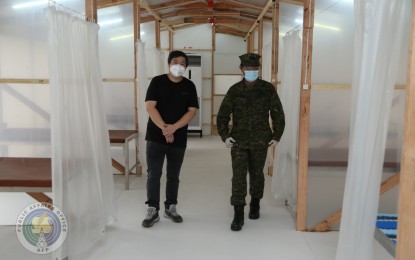 <p><strong>PATIENT CARE CENTER.</strong> AFP vice chief-of-staff, Vice Adm. Gaudencio Collado Jr., (right) and WTA Architecture and Design Studio head Architect William Ti (left) walk through the emergency quarantine facility in Camp Aguinaldo during its inauguration on Thursday (April 9, 2020). The facility will cater to mild and asymptomatic coronavirus disease 2019 patients as part of efforts to decongest hospitals. <em>(Photo courtesy of AFP Public Affairs Office)</em></p>
